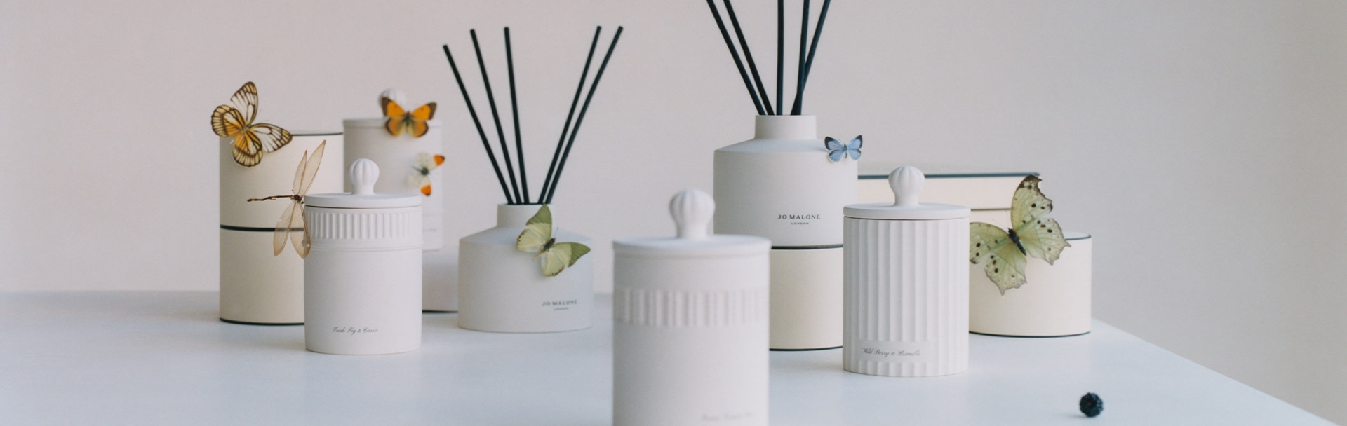 image of jo malone white ceramic townhouse diffusers and candles surrounded by boxes and butterflies