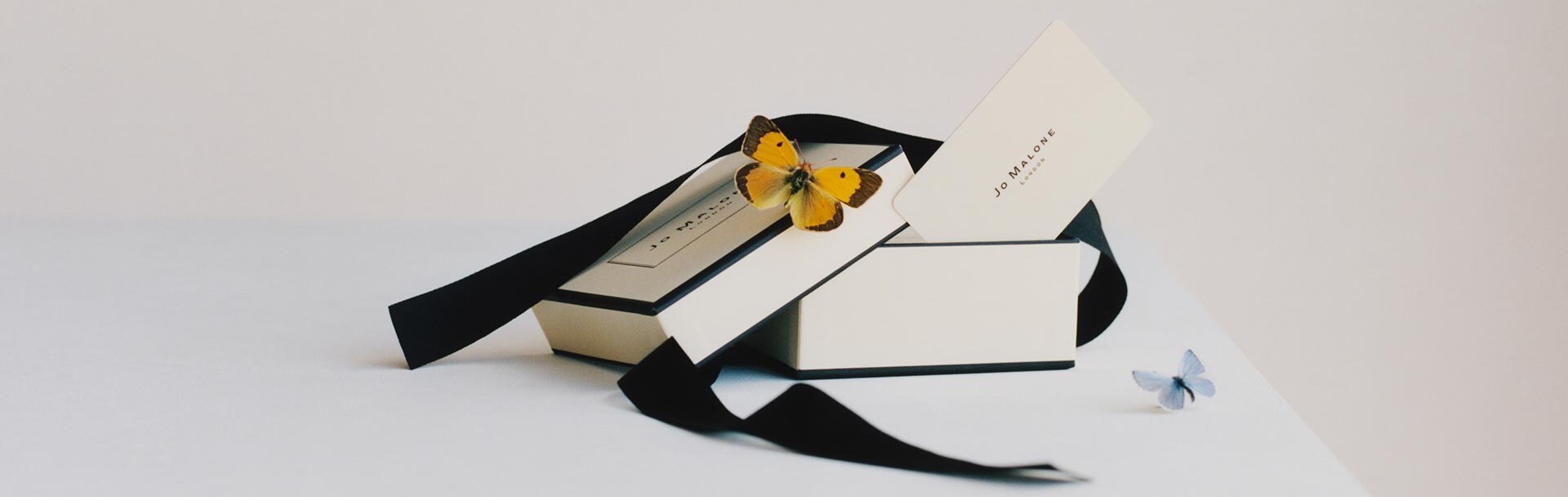 Jo Malone London gift card wrapped in our iconic cream and black gift box, with black ribbon and a yellow butterfly