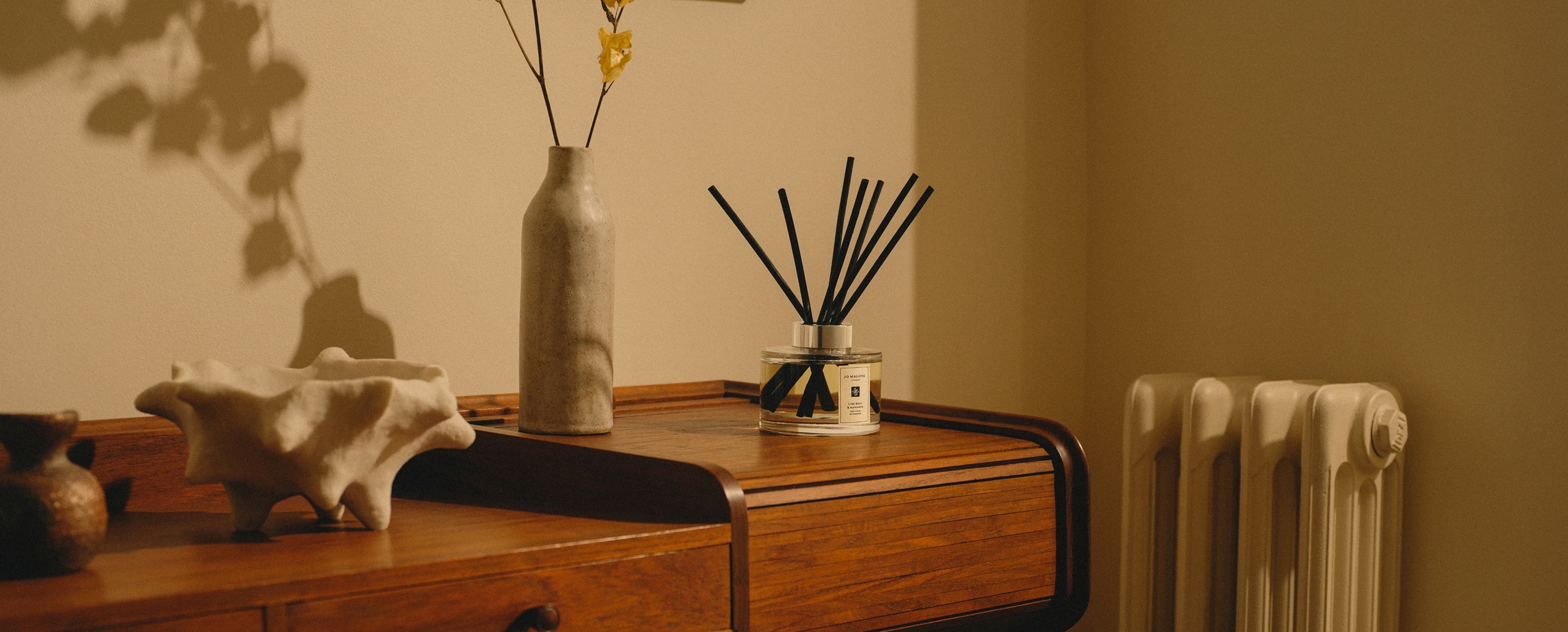 Jo Malone London Diffuser on wooden table with vase & flowers