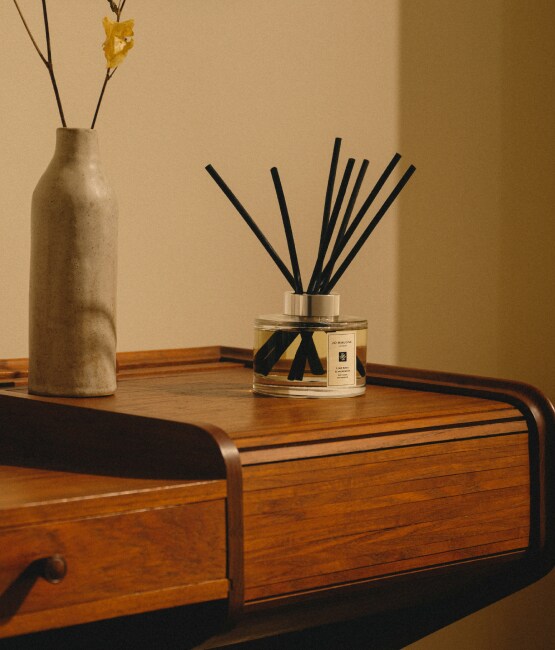 Jo Malone London Diffuser on wooden table with flowers in vase