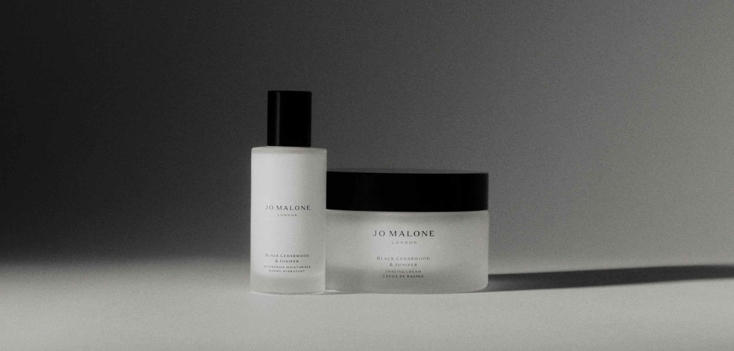 A black and white video of a person using various Jo Malone London products to apply to face.
