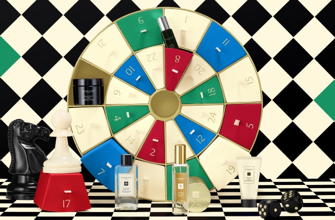 Launch image of advent calendar dartboard box shown open with examples of 5 product contents on checkerboard background.