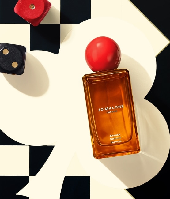 Ginger Biscuit Cologne with red sphere lid, checkered background and dice