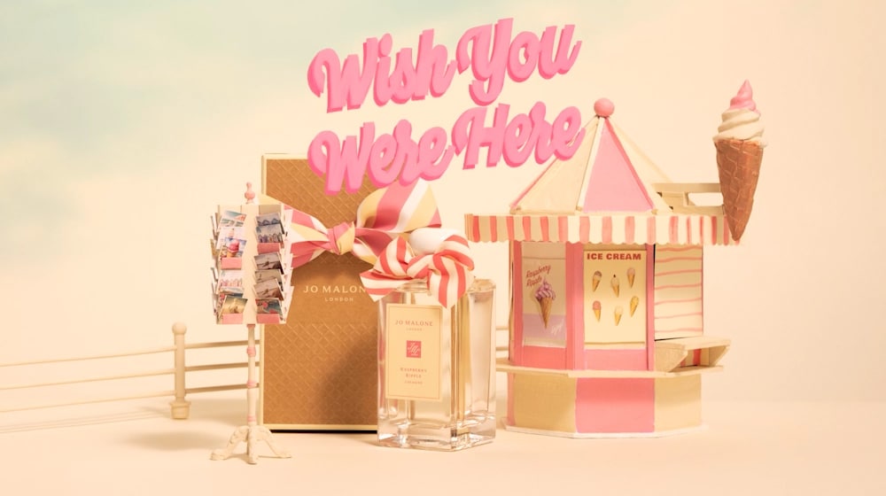 Illustration of Raspberry Ripple Cologne, Box, Postcards and beach hut with 'Wish You Were Here'