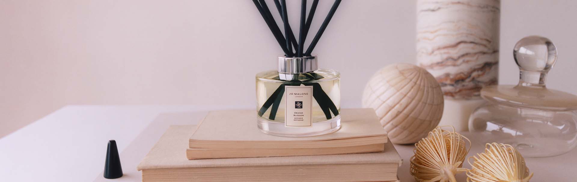 Image of orange blossom room diffuser sat on top of books