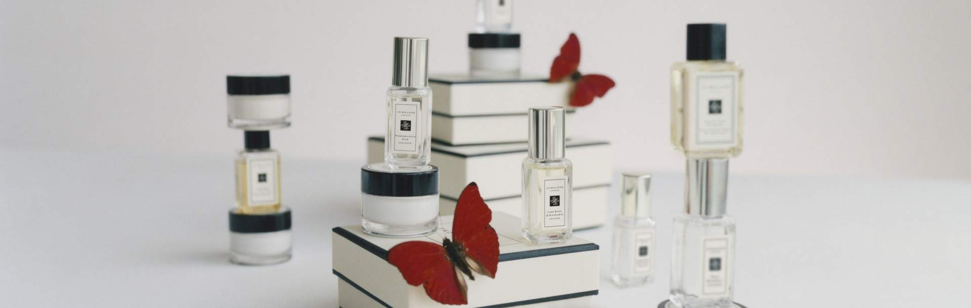 Jo Malone London gift boxes and miniature colognes and body cremes on a table with butterflies